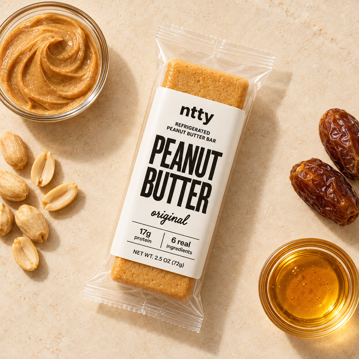 ntty Peanut Butter original protein bar surrounded by a bowl of peanut butter, peanuts, dates, and honey