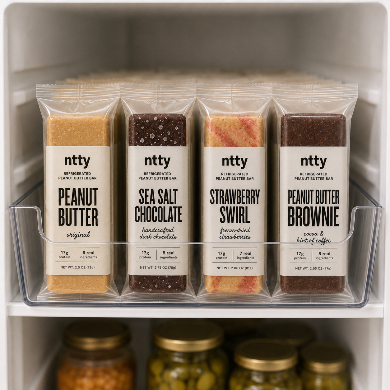 Four ntty refrigerated peanut butter bars arrived in the refrigerator. The flavors shown are original peanut butter, sea salt chocolate, strawberry swirl, and peanut butter brownie.