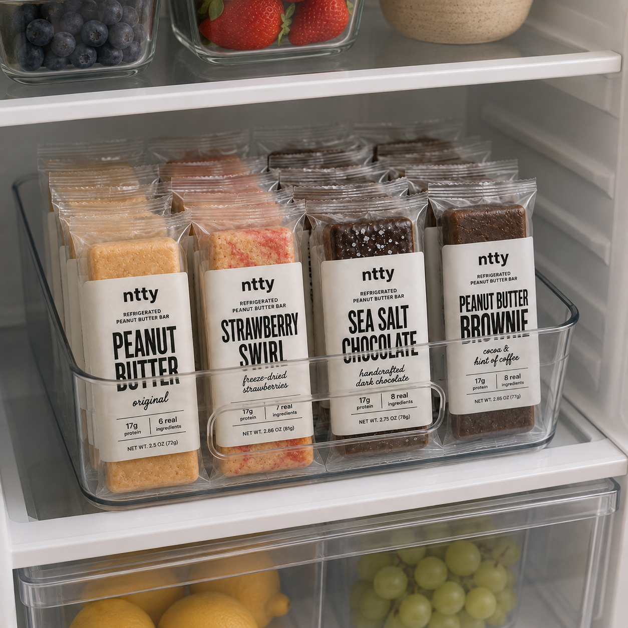 All four ntty refrigerated protein bar flavors in the refrigerator. The flavors are original peanut butter, strawberry swirl, sea salt chocolate and peanut butter brownie.