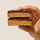 A hand holding two cross-sections of the ntty sea salt chocolate bars.